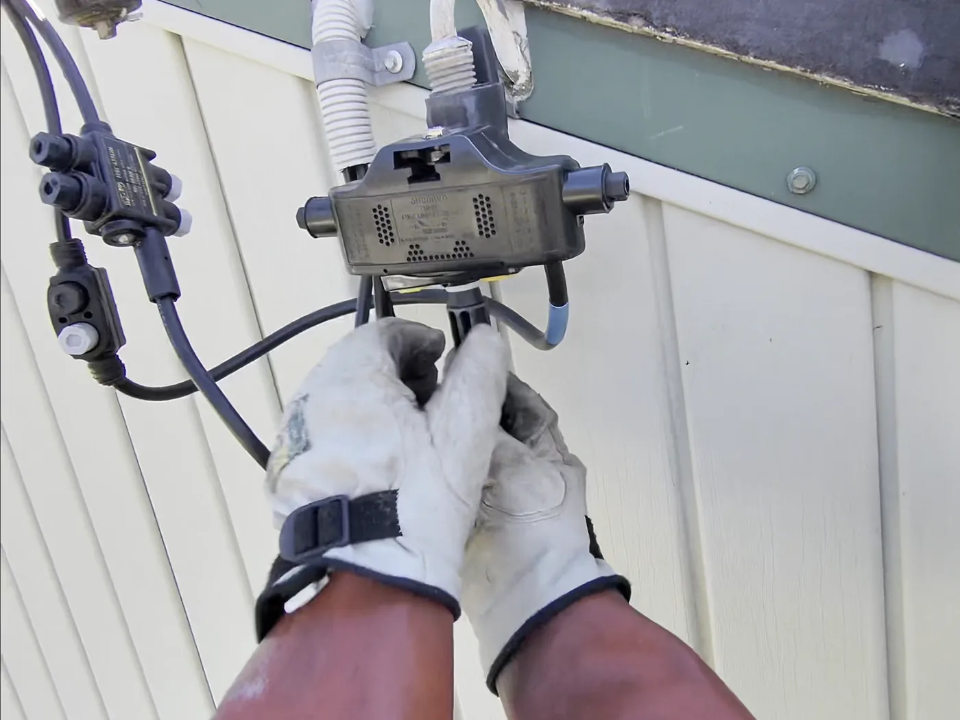 Venux electrician working on overhead service connection equipment