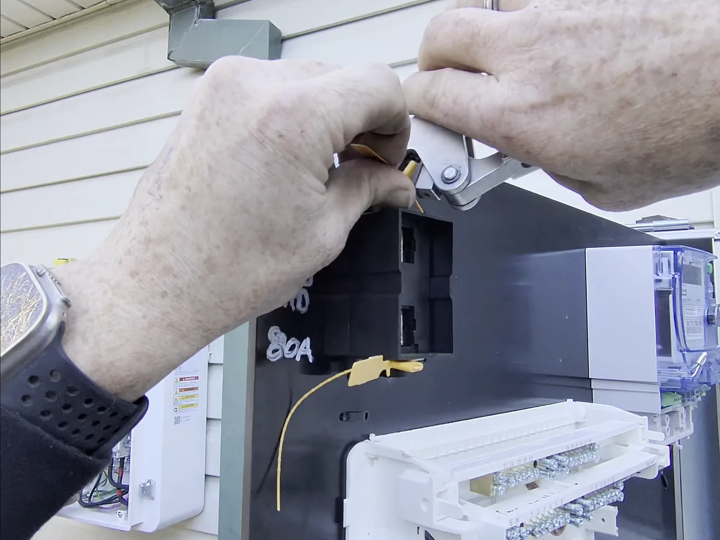 Venux electrician testing service equipment inside an electrical enclosure