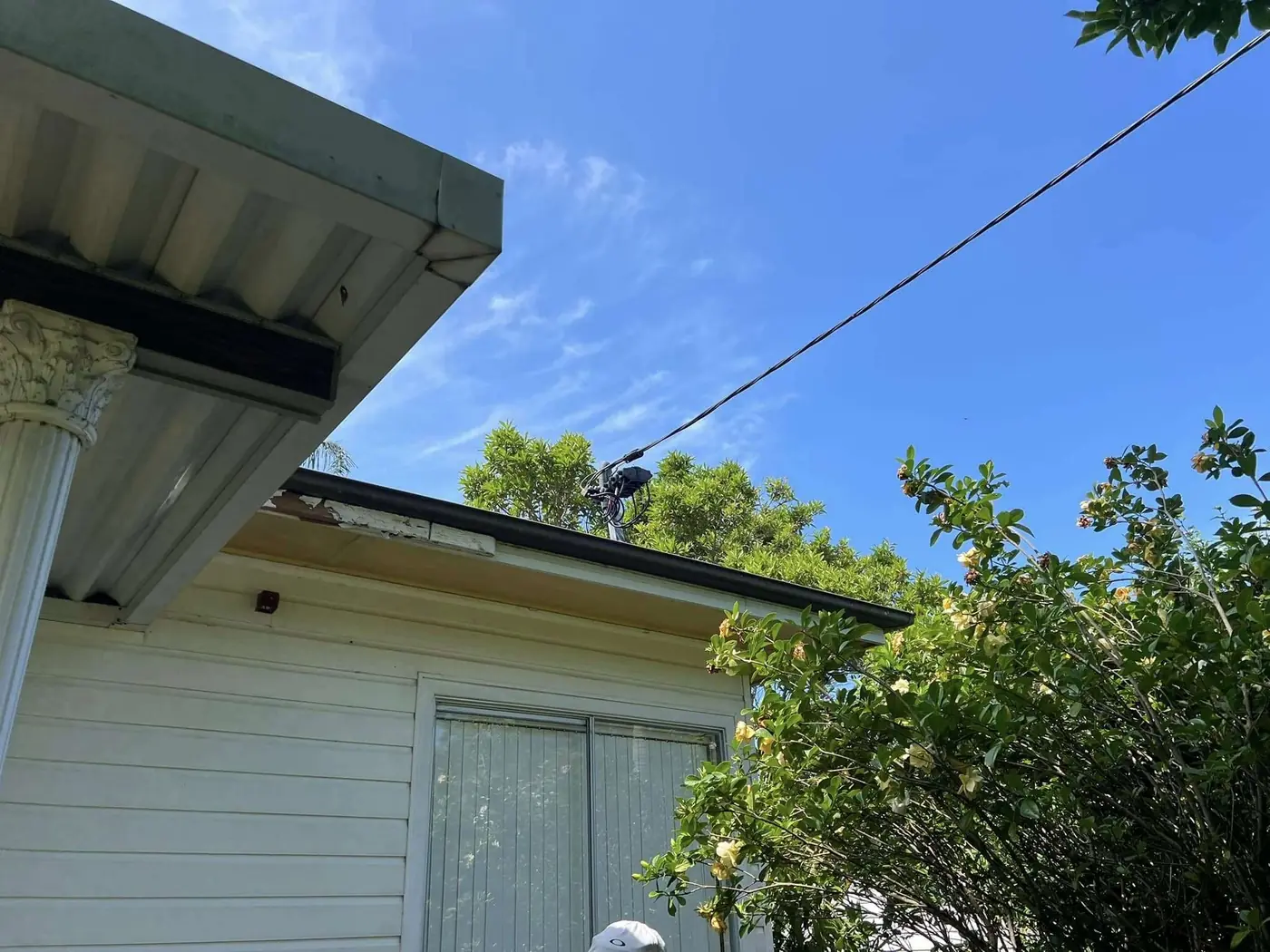Overhead electrical service line running into a house