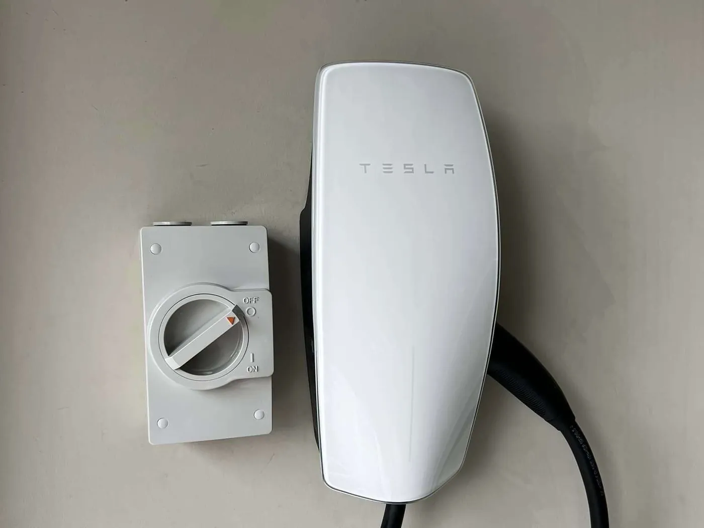 EV charger mounted on a house wall with the lead coiled