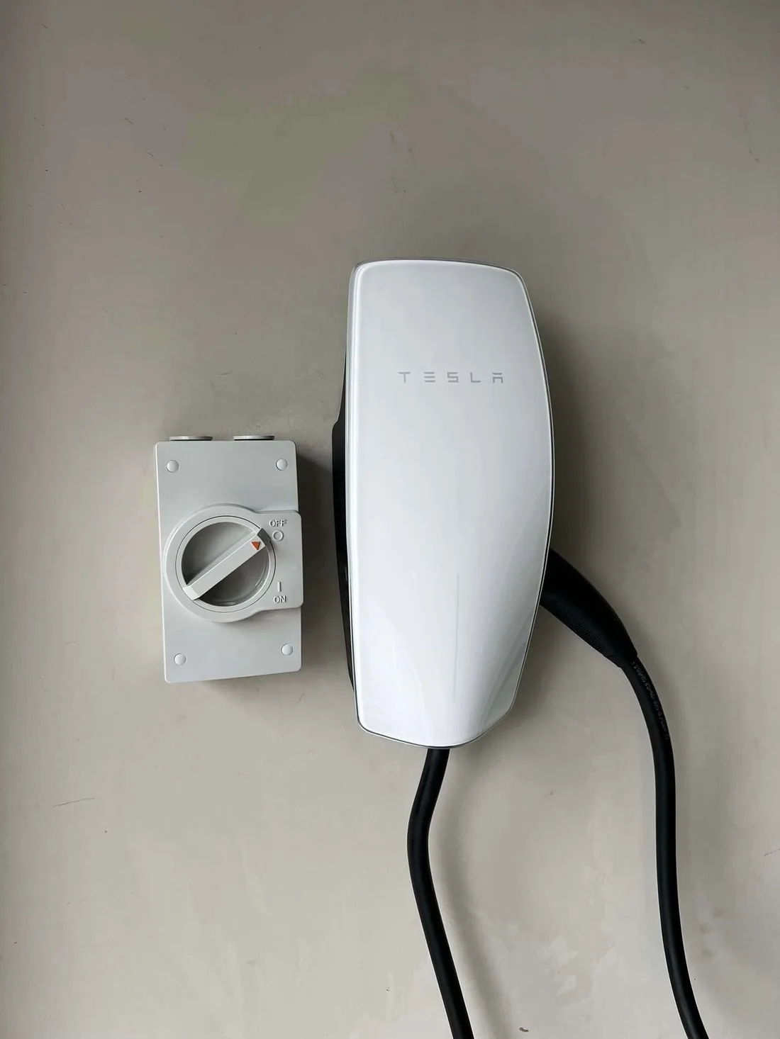 EV charger mounted on the wall with the lead coiled