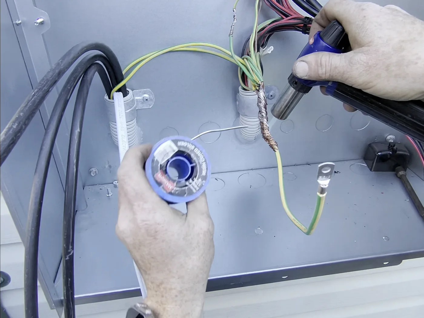 Venux electrician working at an overhead property service connection